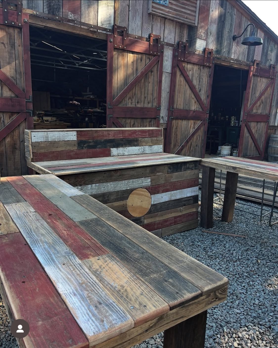 Handmade reclaimed-wood benches and tables outside the barn at The Colfax Bazaar.