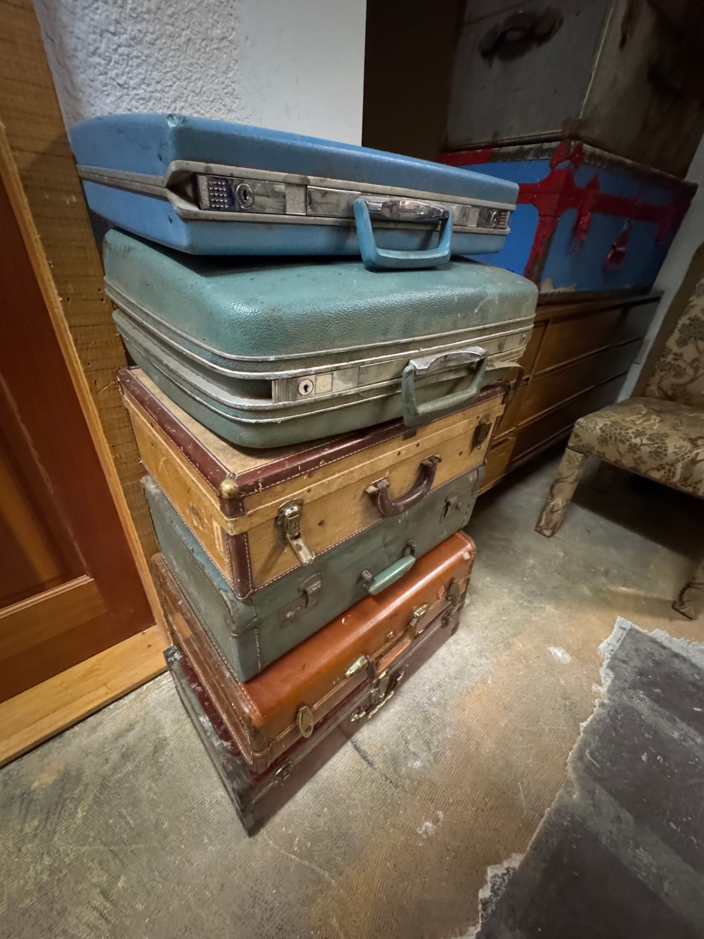 A stack of vintage suitcases and trunks among the antiques.
