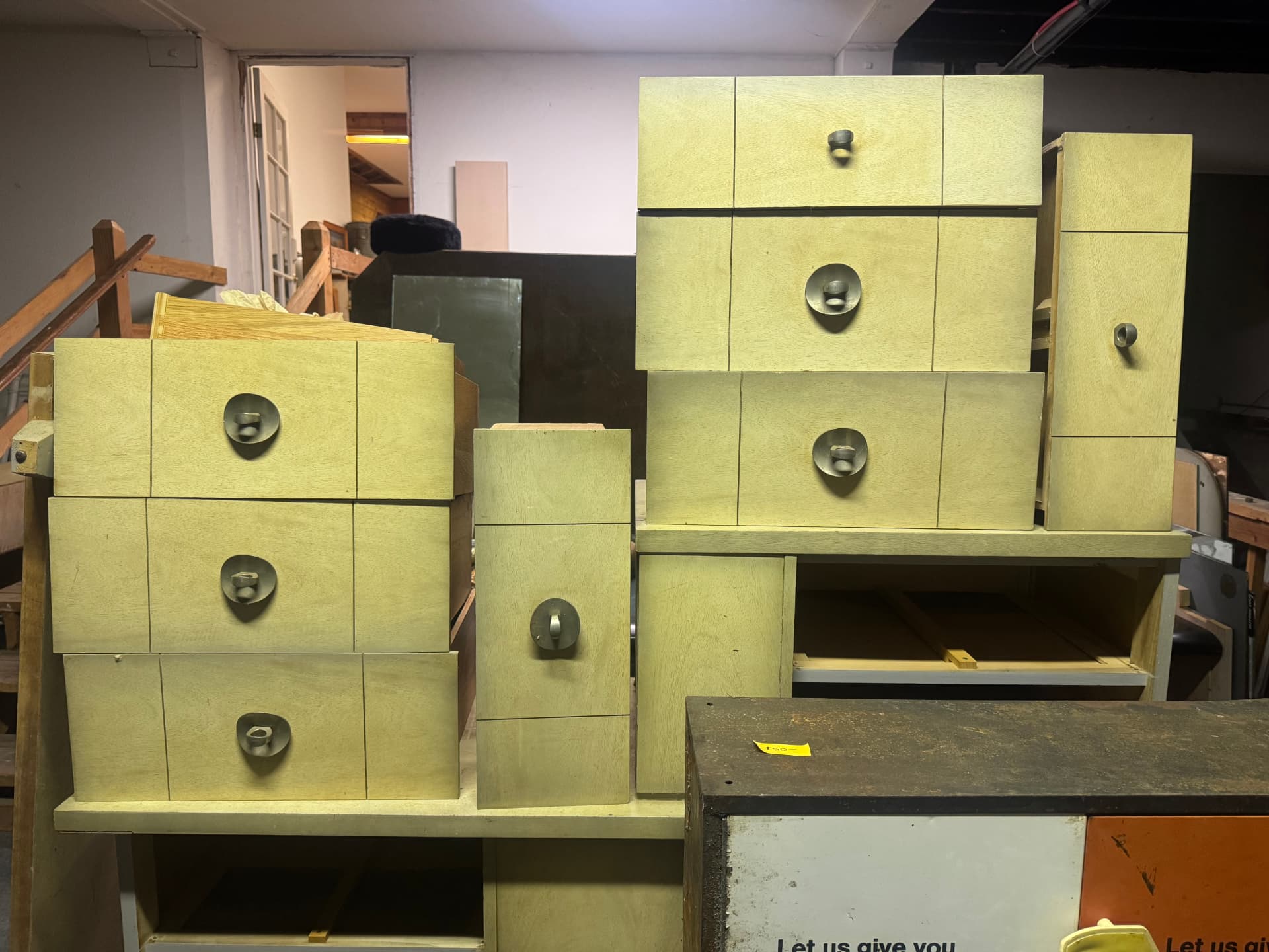 Stacks of pale green vintage cabinet drawers with metal pulls.
