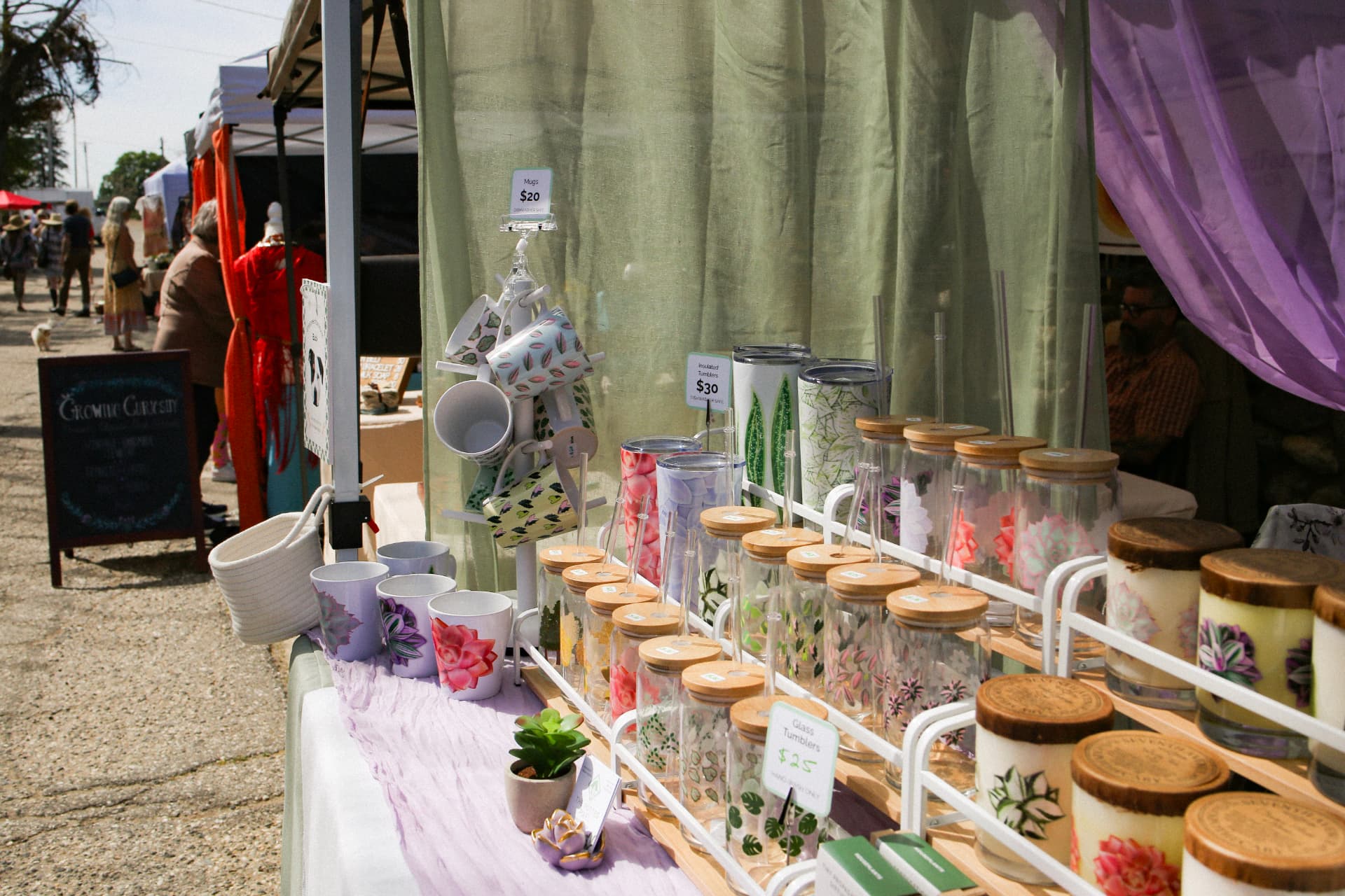 A booth of hand-painted mugs, glass tumblers, and candles at The Colfax Bazaar.